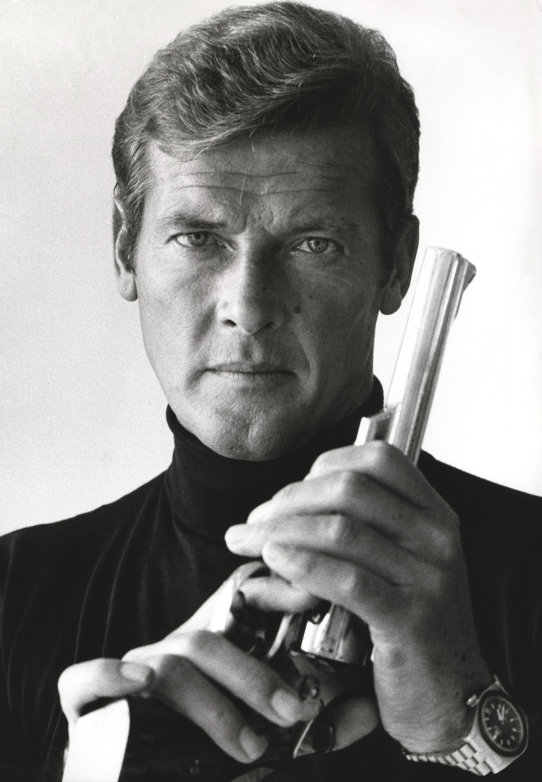 Roger Moore as James Bond holding a pistol, an Archival Print - Art ...