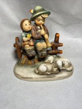 hummel boy sitting on fence