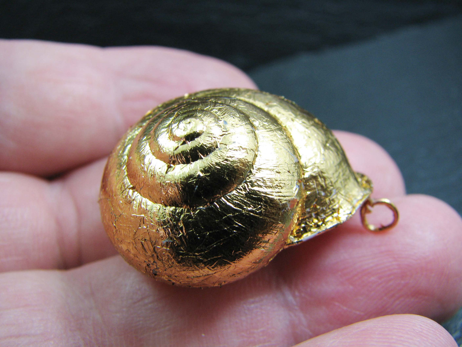 A unique golden hand made natural land snail shell pendant. Jewelry
