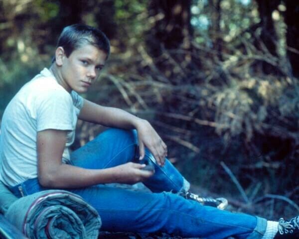 River Phoenix in t-shirt & jeans seated in woods stand By Me 24x36 inch Poster