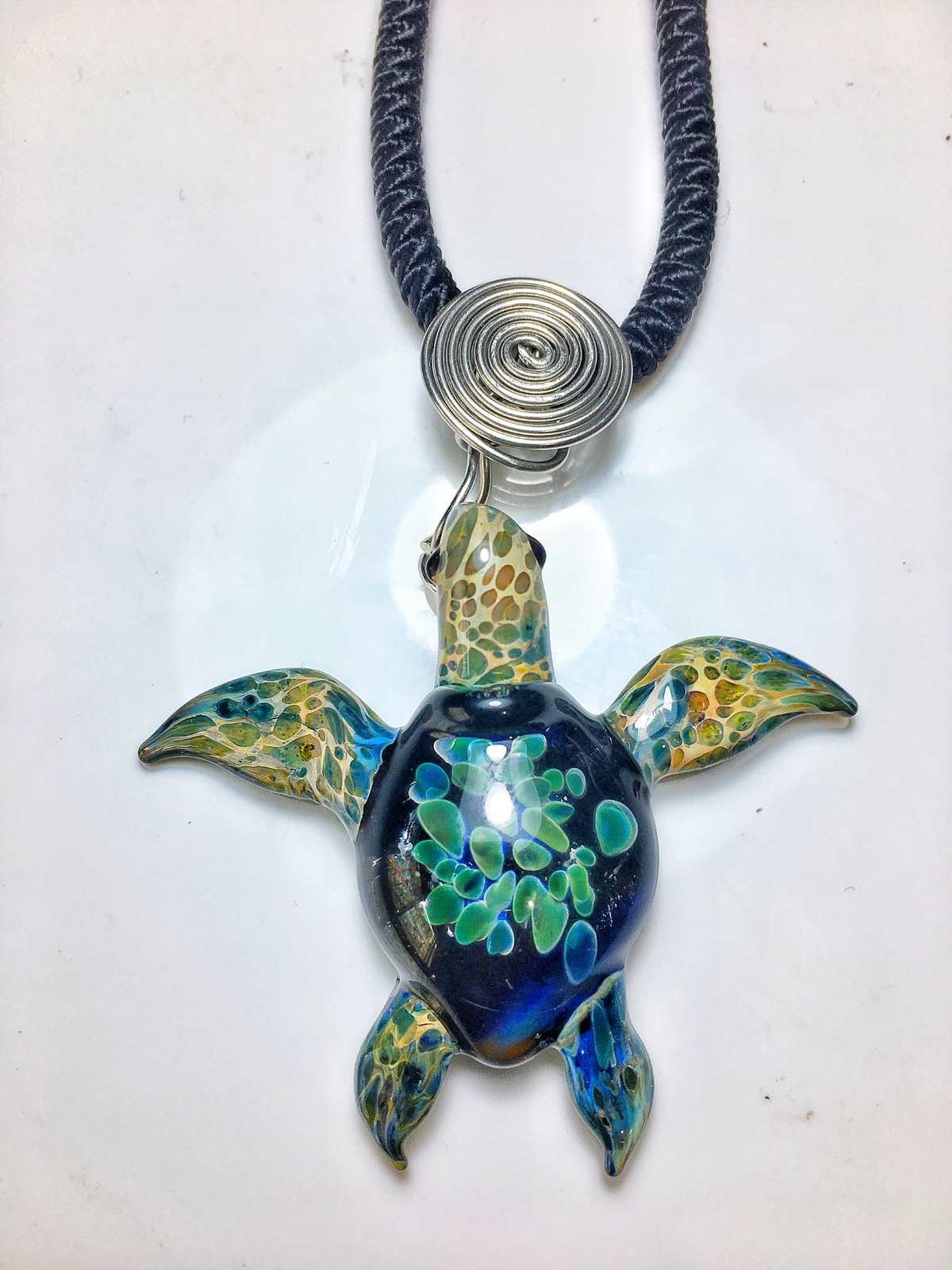 Glass turtle pendant of an Amazon night colored body and emerald green ...