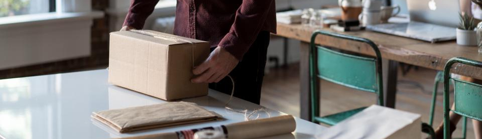 person wrapping package with string