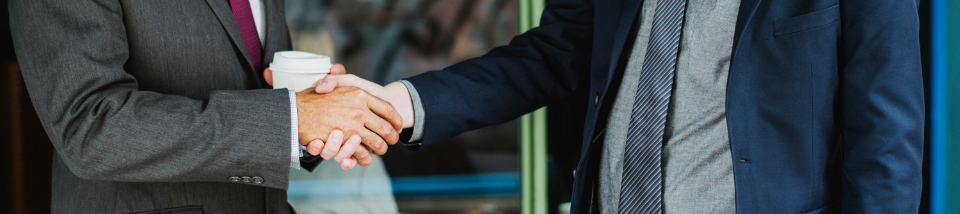 two people in business suits shaking hands