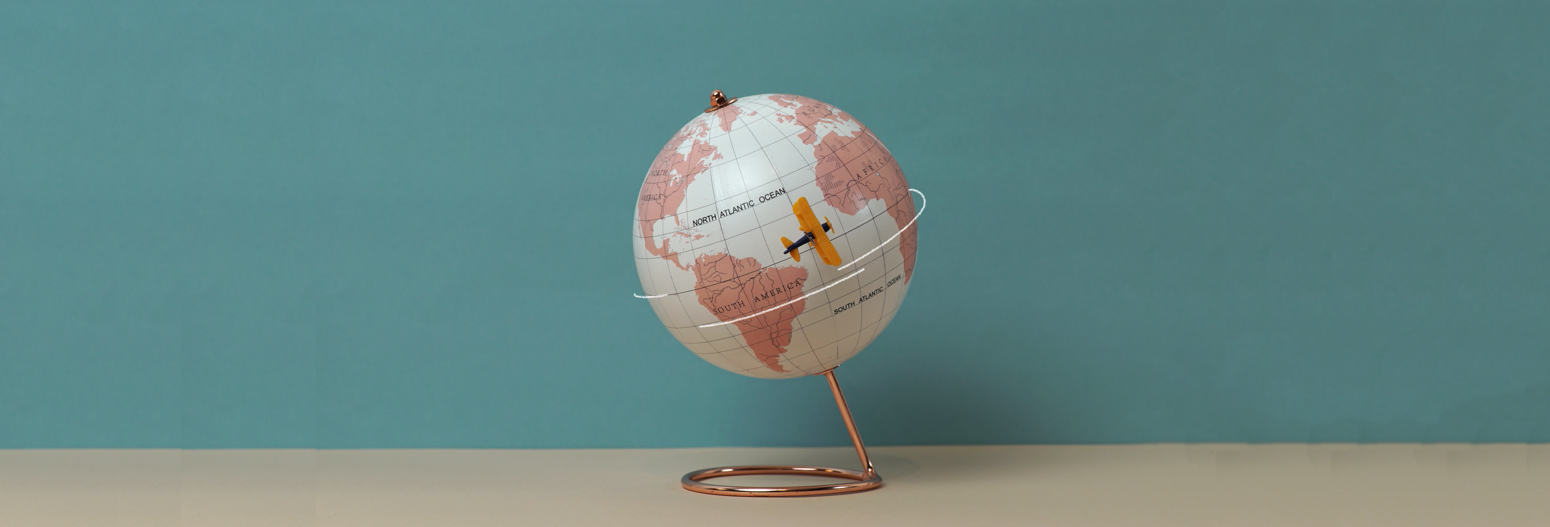 image of globe with toy airplane flying by