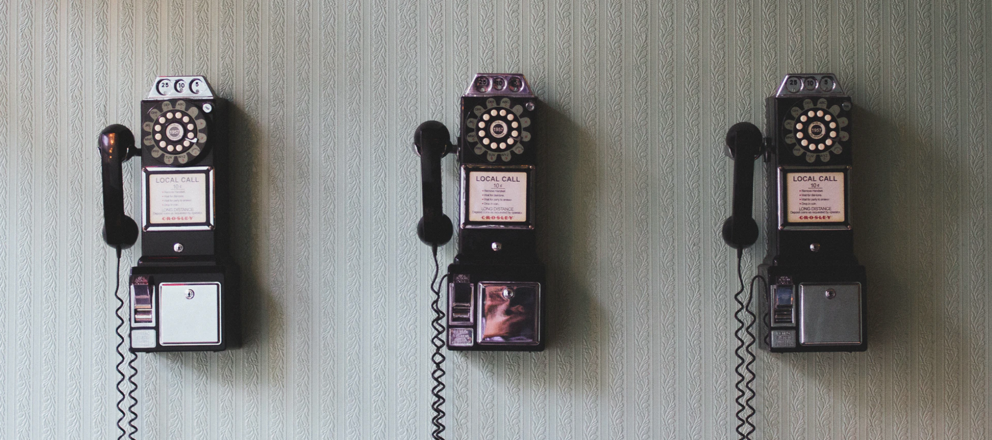 image of 3 early 19th century land line phones on wall